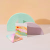 Birthday card with abstract design and envelope, displayed in front of geometric foam shapes in pastel colors, on a light surface with a peach background.