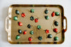 Gold tray with a string of red and green star and heart ornaments.