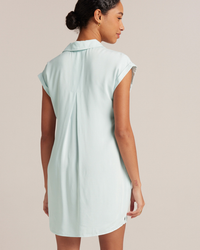 Woman standing in a Bella Dahl Cap Sleeve V-Neck Dress in Sea Foam, viewed from the back.