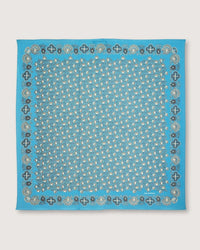 This square bandana, known as Bandana No 675 in Cloud by Moismont, showcases a detailed paisley and floral pattern in white and dark blue on a soft cotton fabric. Its intricate border designs enhance the elegance of this stylish accessory.