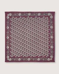 The Moismont Bandana No 675 in Plum, crafted from cotton and showcasing a screen-printed white paisley pattern with a decorative border, is displayed flat on a plain background.