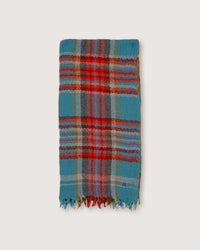 A folded, hand-woven scarf from Moismont's "Scarf No 699 in Cloud" series, showcasing a multicolored plaid design with shades of blue, red, and green, finished with fringe on one end and set against a plain background.