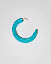 A blue, crescent-shaped C Hoop in Small earring hand-carved from sustainably sourced mango wood by B&L on a white background.